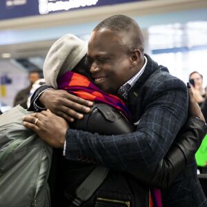 Celestine Mugisha and his wife, Winniefred Akello, embrace at O’Hare International Airport as they are reunited after living apart for more than three years, Jan. 22, 2020. Mugisha and Akello were married in Uganda in September 2016 and, days later, Mugisha moved to Chicago as part of the United States’ refugee resettlement program. More than three years later, Akello was also resettled through the program.