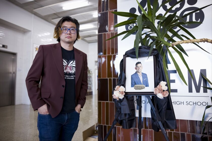 Board of Ed President Jianan Shi stands next to a photo of the late Rigo Padilla Perez, his former colleague and close friend.