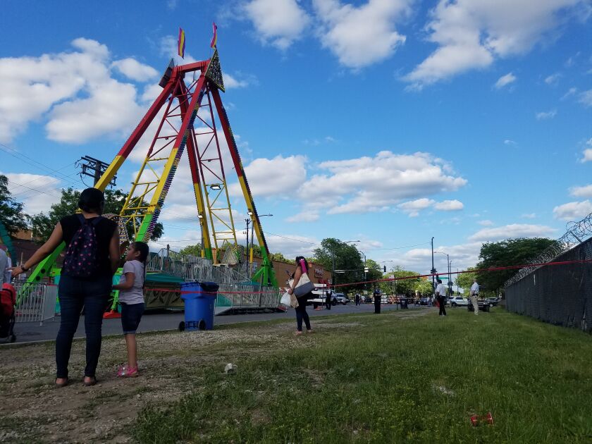 A mother and her daughter wait for a ride at a carnival Sunday near the scene of a shooting. | Nader Issa/Sun-Times