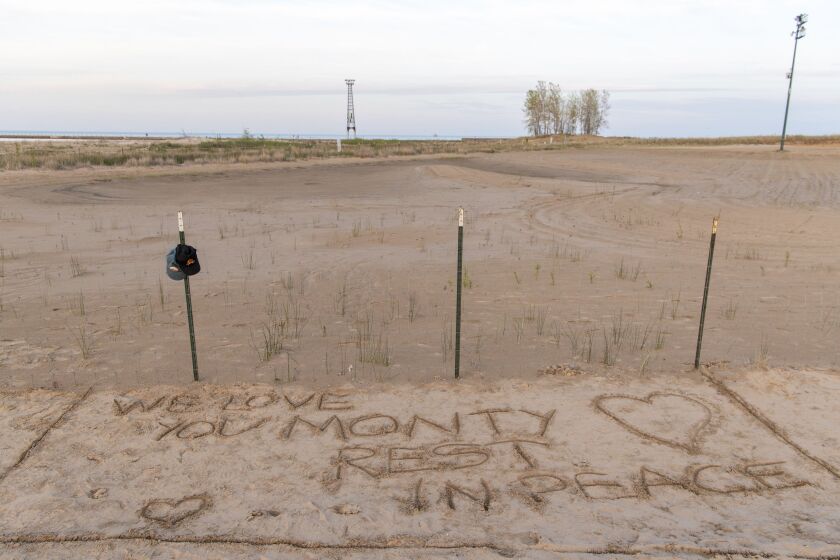 Two piping plover hats hang on a post at a memorial for Monty at Montrose Beach, near where the piping plover died on May 13, 2022.