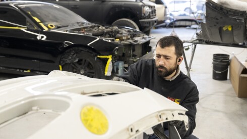 An employee at River North Collision Repair who goes by “Surge” works on the bumper of a vehicle in the West Town auto shop, Thursday, Dec. 4, 2025. | Tyler Pasciak LaRiviere/Sun-Times