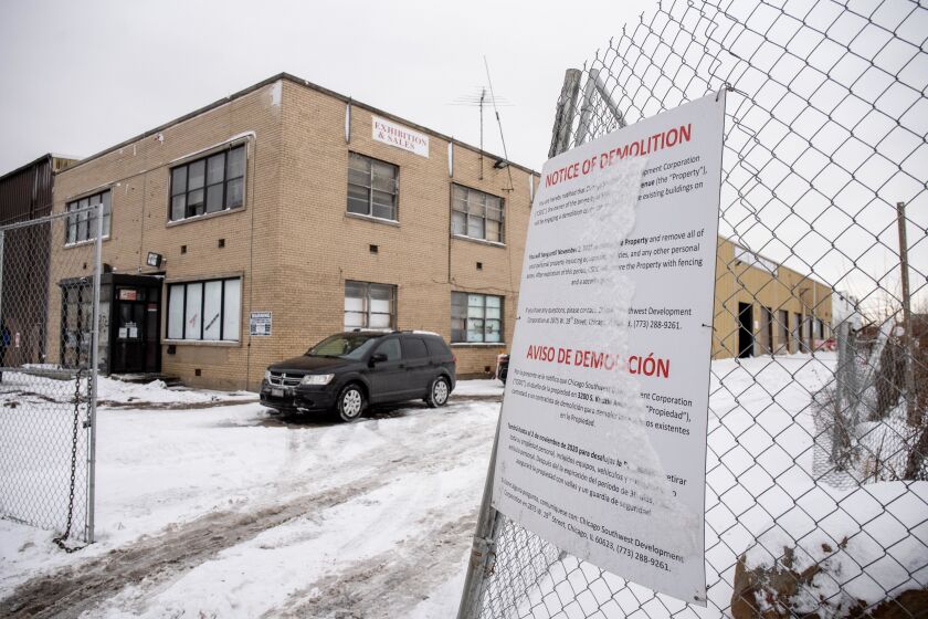 A security guard sits in his car near a demolition notice that hangs on the fence at 3200 S. Kedzie Ave. in the Little Village neighborhood, Wednesday afternoon, Jan. 27, 2021.