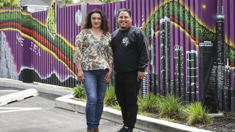 Artists Alma Dominguez and Mario Mena stand in front of their new murals at PODER in Gage Park.