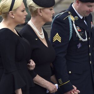 Cindy McCain, center, flanked by her children Meghan McCain, left, and Jimmy McCain, right, watch as the casket of Sen. John McCain, R-Ariz., arrives at the Washington National Cathedral in Washington, Saturday, Sept. 1, 2018, for a memorial service. McCa