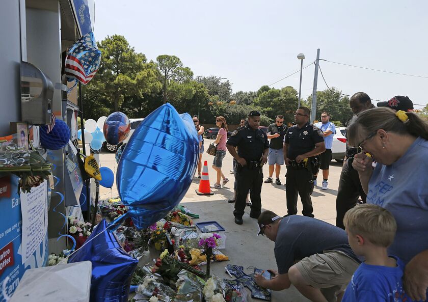 People pay respects Saturday at a makeshift memorial for Harris County, Texas, Sheriff’s Deputy Darren Goforth, who was gunned down Friday at a gas station hear Houston. James Nielsen/Houston Chronicle via AP