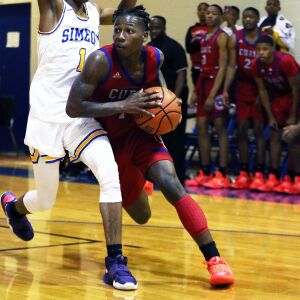 Curie’s Elijah Pickens, right, works his way toward the basket as Simeon’s Jaylen Drane defends.