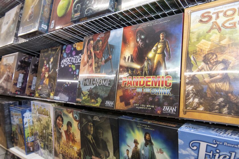 The game Pandemic along with a variety of other board games hangs on shelves at Chicagoland Games Dice Dojo at 5550 N. Broadway Ave., Thursday, March 19, 2020.