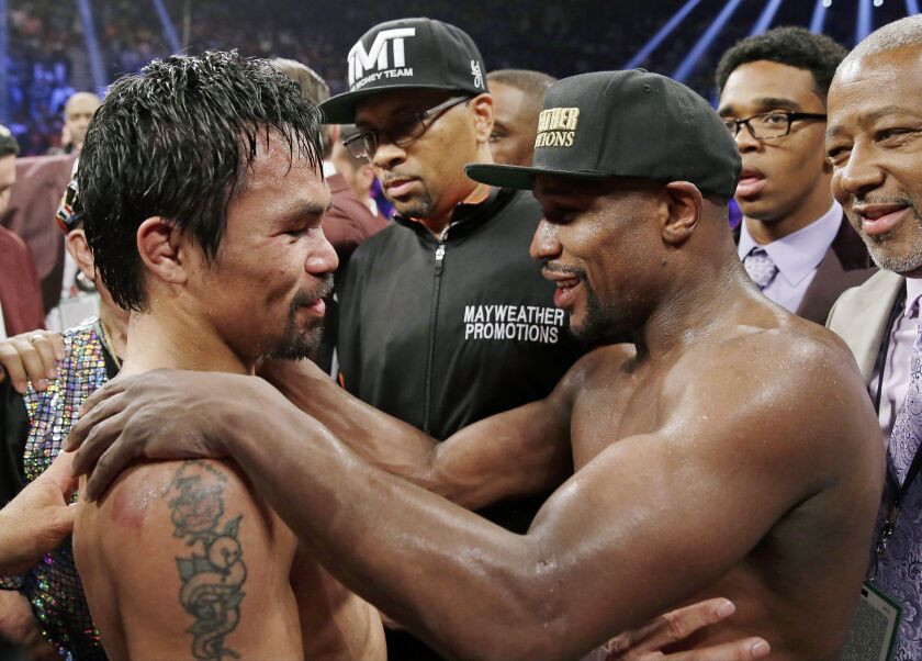 FILE – In this May 2, 2015, file photo, Manny Pacquiao, left, from the Philippines, and Floyd Mayweather Jr., embrace in the ring at the finish of their welterweight title fight in Las Vegas. Mayweather Jr. says he’s coming out of retirement again to figh