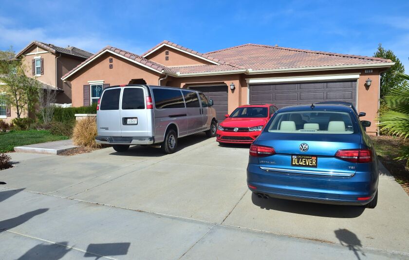 Vehicles remain in the driveway of 160 Muir Woods Road from where authorities rescued 13 malnourished children held captive by their parents in Perris, California. | Frederic J. Brown/AFP/Getty Images