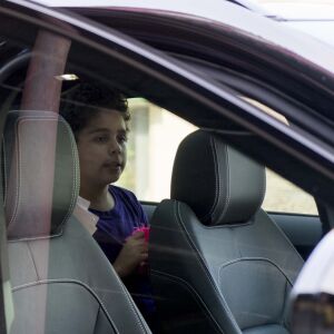 Nine-year-old Diogo waits in the car after reuiniting with his mother, Lidia Souza. | Pat Nabong/For the Sun-Times