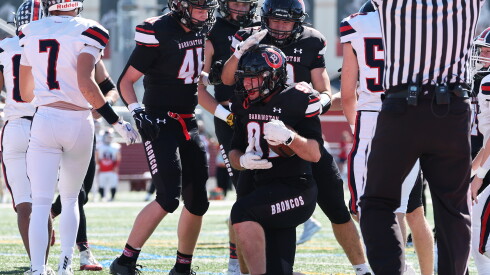 Barrington's Cru Lucier (97) gets a pat on the head from Donovan Bjerregaard-Dionne (0) after recovering a blocked punt in the end zone to score the Bronco's first touchdown of the afternoon against Conant.