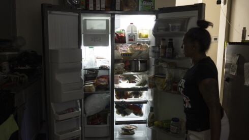 Melissa Dixon shows off the food in her refrigerator in Gary, Ind.