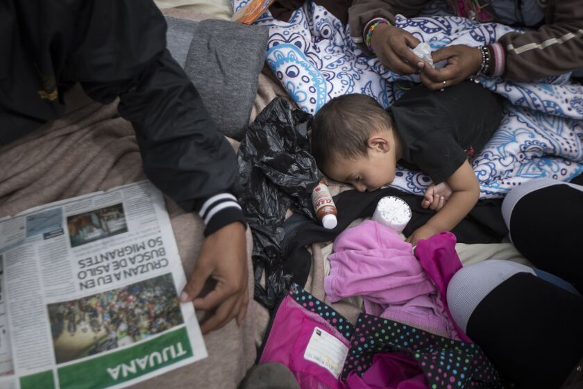 A two-year-old child from Honduras gets treatment for an ear infection in front of the El Chaparral port of entry, in Tijuana, April 30. (AP Photo/Hans-Maximo Musielik)