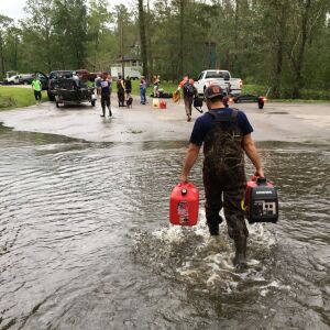 Kevin Knox carries gas and a generator after being rescued from his flooded neighborhood from the effects of Florence, now a tropical storm, in New Bern, N.C., on Saturday, Sept. 15, 2018. (AP Photo/Allen G. Breed)