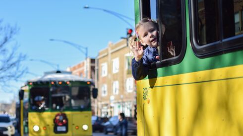 Four-year-old Greta Bryant leans out the window of a trolley rented by the Greater Ravenswood Chamber of Commerce to bring people to local shops on Small Business Saturday Nov. 26, 2022.