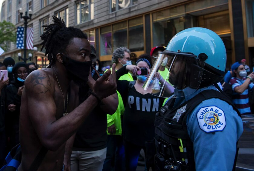 A protester gives a Chicago police officer the finger during last summer’s protests in the Loop.