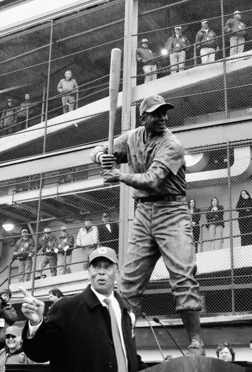 Chicago Cubs Hall of Fame baseball player Ernie Banks talks about his career at the foot of his newly unveiled statue outside Wrigley Field during ceremonies in Chicago, Monday, March 31, 2008. (AP Photo/Charles Rex Arbogast)