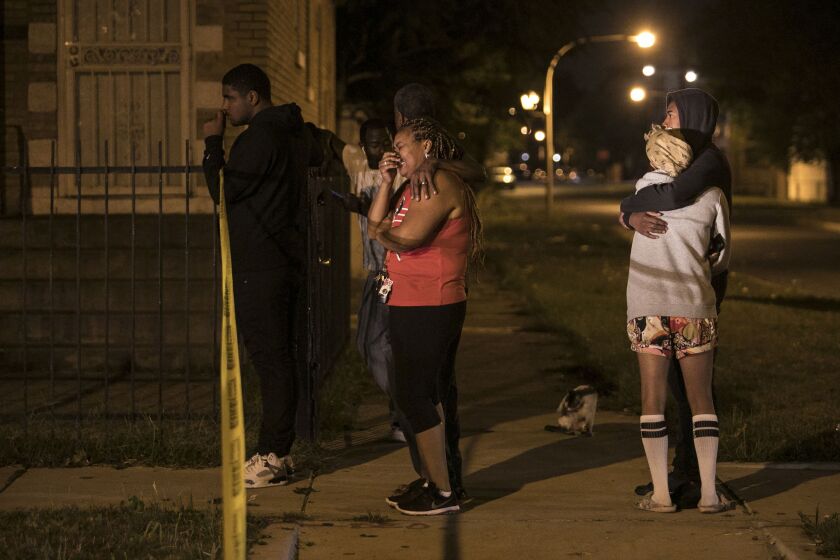 Family members and friends watch as Chicago Police investigate in the 6600 block of South Oakley, where a 28-year-old man was shot to death early Tuesday, Sept. 26, 2017. | Ashlee Rezin/Sun-Times