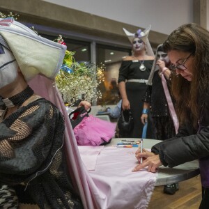 A woman writes names on Sister Auntie Gayme’s Cloak of Remembrance at Centers on Halsted during Transgender Day of Remembrance event Thursday, Nov. 20, 2025.