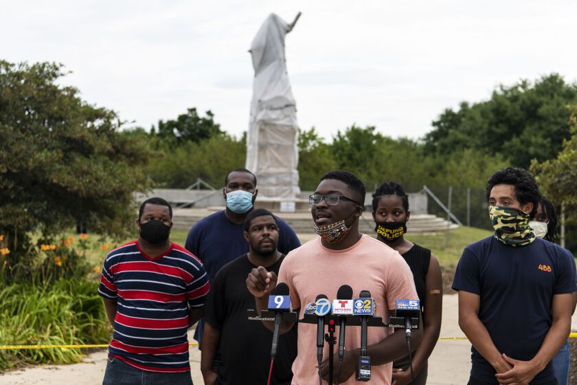 Activist Ja’Mal Green and representatives with Good Kids Mad City speak to reporters near the statue of Christopher Columbus in Grant Park in July.