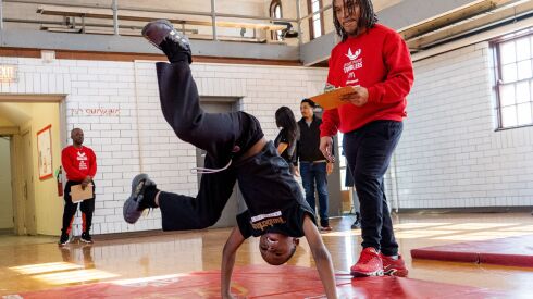 Jermaine Hardaway, 7, who was accepted into the Jesse White Tumblers, performs a cartwheel while coach Anthony Cabin watches at Tuley Park, Saturday, Feb. 4, 2023.