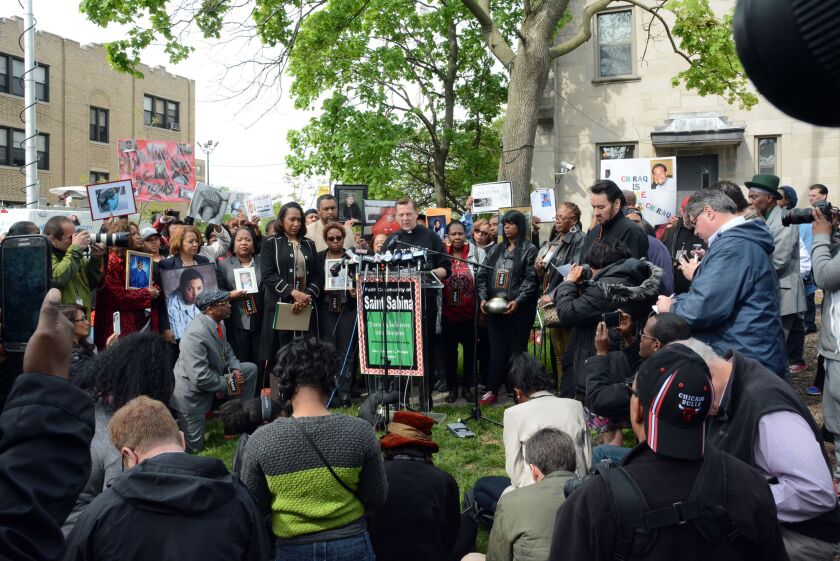 Rev. Michael Pfleger spoke at a news conference outside St. Sabina last month about Spike Lee’s new movie. Lee is kneeling in front of the lectern at left; actor John Cusack, who is in the film, is standing to Pfleger’s left. | Sun-Times File Photo