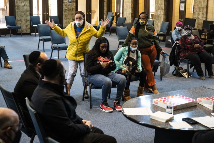 Flanked by other residents, Tamara Jackson (in yellow), 43, who has lived with her five kids at Concordia Place Apartments for 12 years, speaks with representatives from property owners Capital Realty Group, complaining of rats, mold and more in her unit, during a meeting Tuesday at the Far South Side apartment complex.