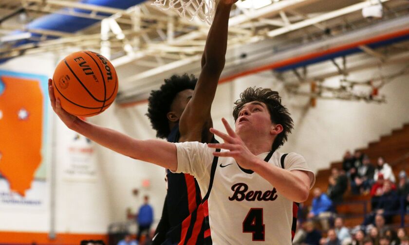 Benet’s Patrick Walsh (4) goes up and under the basket to lay the ball off the glass against Oak Park.