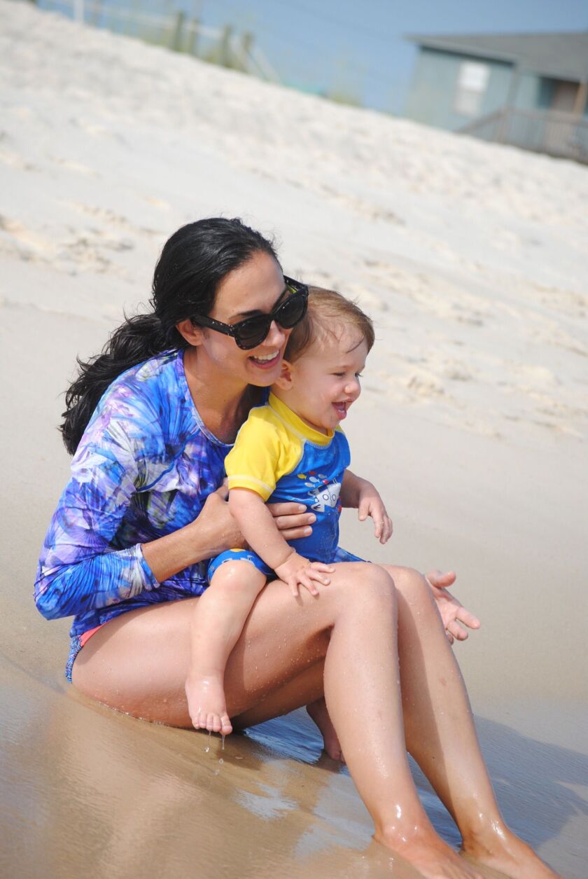 Nicole Hughes holding her son Levi on a beach outing.