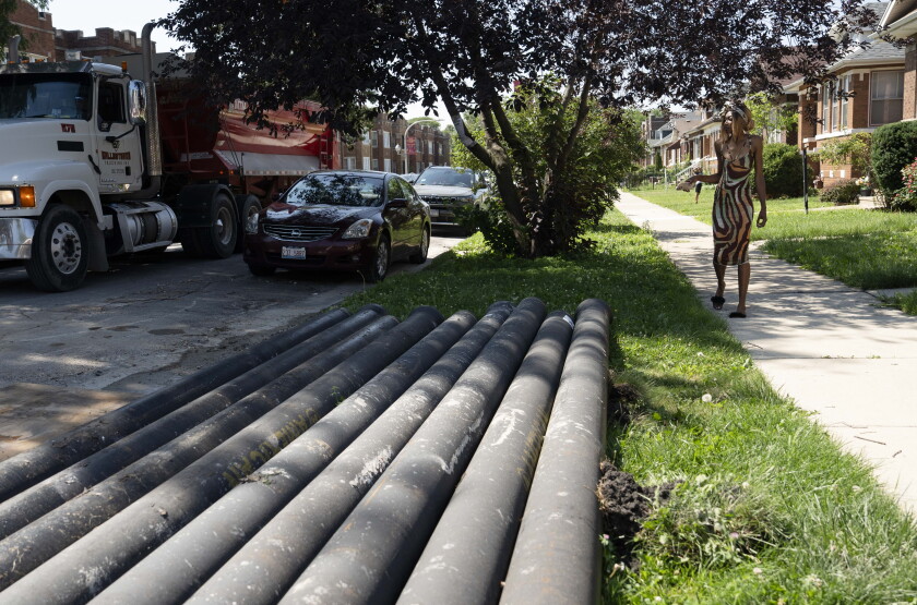 A resident walks near pipes in the 1400 block of North Linder Avenue in Austin.