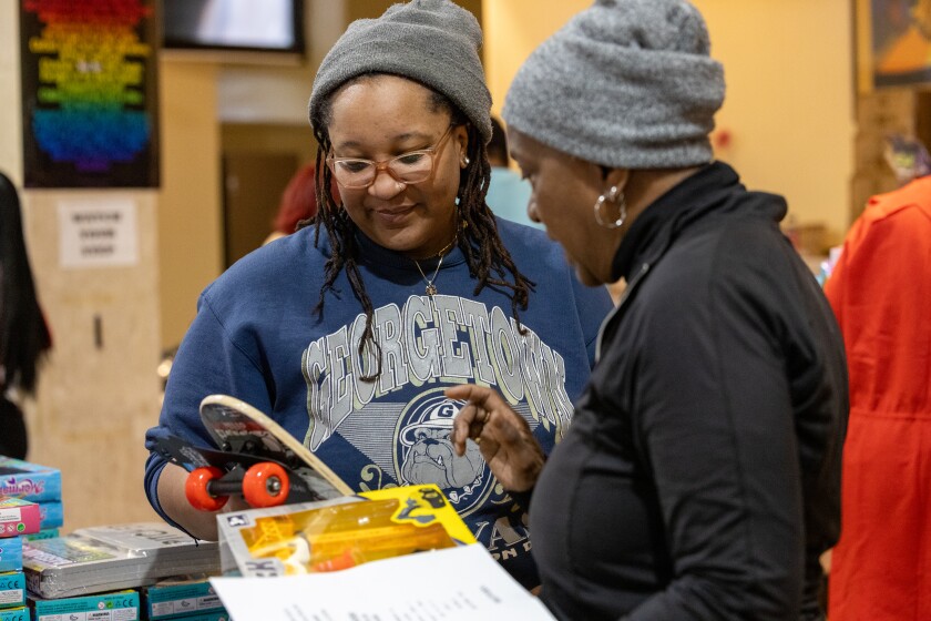 Jasmine Gill, left, and her mother, Judy Cuascut, who have volunteered together for five years, help pack toys Christmas morning at St. Sabina Church.