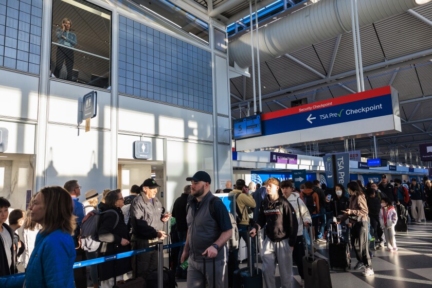 Travelers wait in line at terminal one at O’Hare International Airport.