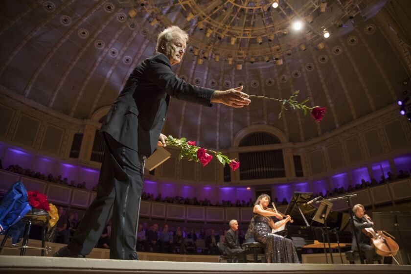 Bill Murray tosses roses to the audience at the conclusion of his “New Worlds” concert Tuesday at Symphony Center. | TODD ROSENBERG PHOTO