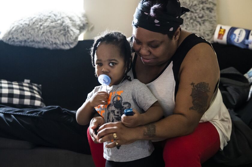 Donna Rogers, 49, plays with her 2-year-old grandson, Kayden Swann, Tuesday morning in her daughter’s South Side apartment. Kayden is blind in his right eye after he was shot in the head on April 6, 2021, during a road rage incident on DuSable Lake Shore Drive near Grant Park.