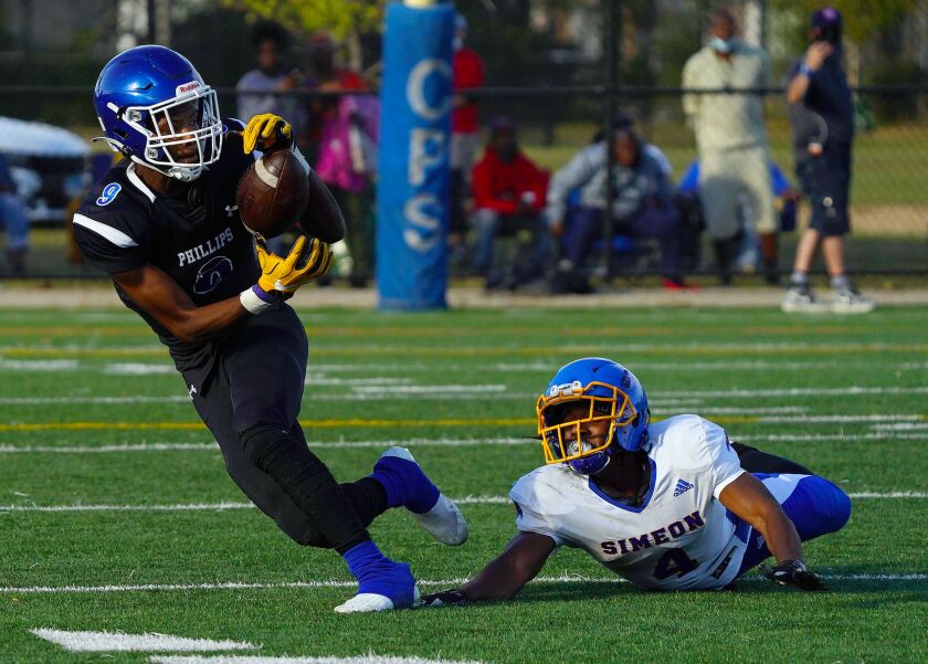 Phillips’ Avante Savage (9) makes the catch with Simeon’s Andre Crews (4) on the ground.