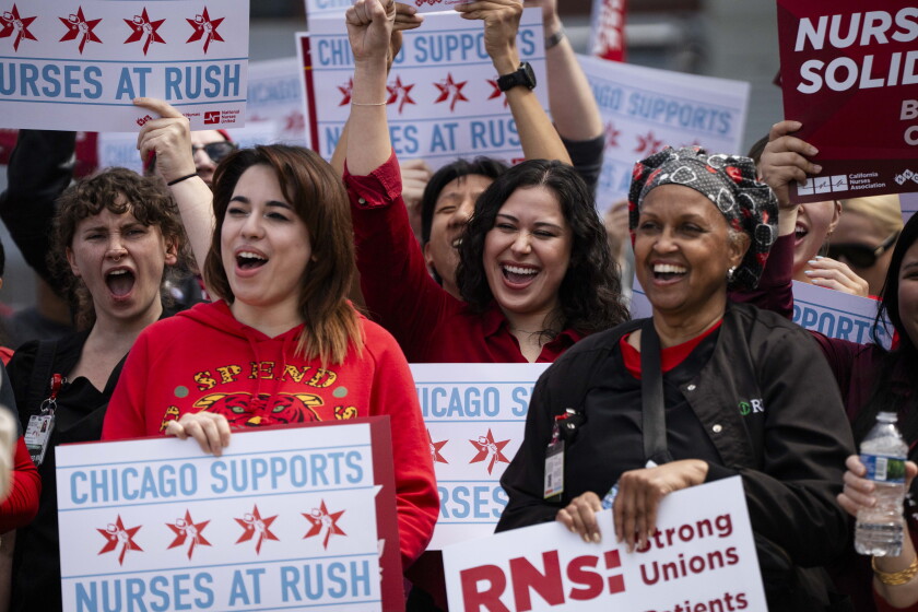 Three nurses rally outside Rush University Medical Center on Thursday, April 9, 2026.