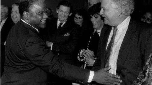 The late Chicago Mayor Harold Washington playfully pats then Chicago Sun-Times chief political columnist Basil Talbott Jr. at his farewell party at the Zolla-Lieberman Gallery.