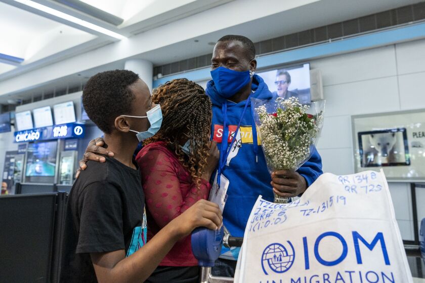 Mwenebatu Mwenemkaba, right, stands with his wife Mapenzi Mweniake and Mussa Mrisho, at O’Hare International Airport’s Terminal 5, Wednesday.