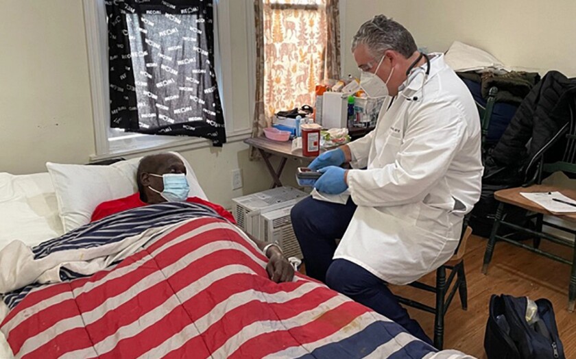 Sam Ferguson gets a COVID-19 shot from Dr. Steven Landers, president and chief executive officer of the Visiting Nurse Association Health Group, in Asbury Park, New Jersey.