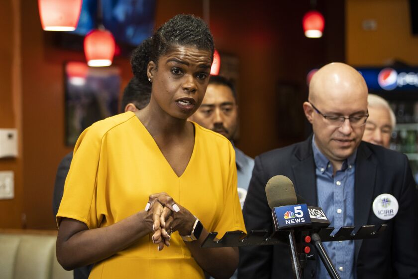 Cook County State’s Attorney Kim Foxx speaks to reporters during a campaign stop at Cecina Grill in Pilsen as Ald. Michael Rodriguez (22nd), right, listens.