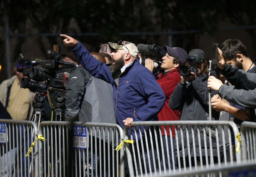 A demonstrator who wants to keep Confederate-era monuments in place yells as workers dismantle the Liberty Place monument early Monday. The monument commemorates whites who tried to topple a biracial post-Civil War government, in New Orleans. It was remov