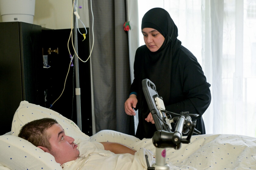 Asmaa attends to her disabled son Omar