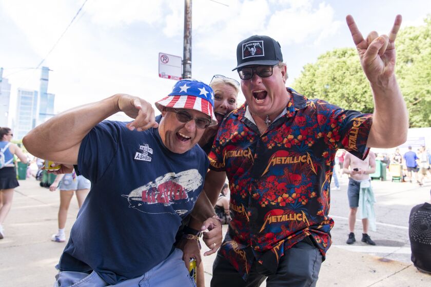 From left, long time metallic fans George Reed, Peggy Richards, and Alex Genova pose for a photo, during the first day of Lollapalooza at Grant Park, Thursday, July 28, 2022.