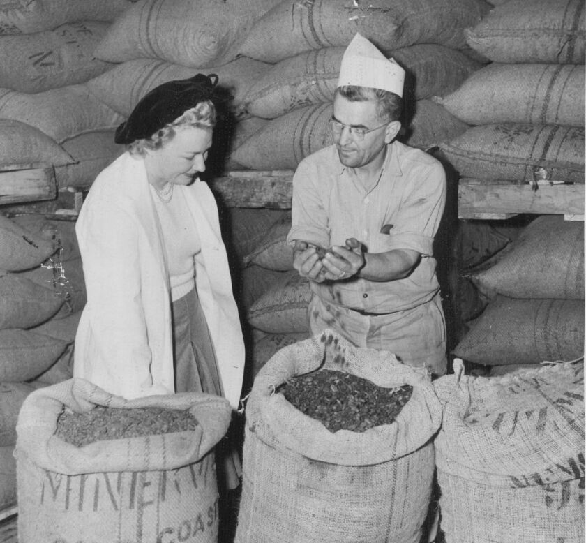 A worker at E.J. Brach & Sons in Chicago shows imported cocoa beans to a visitor in 1949.