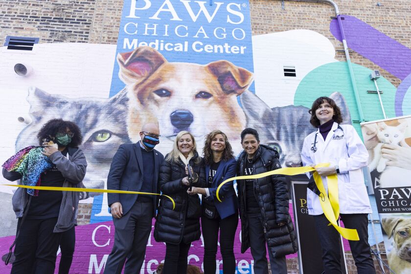 PAWS founder Paula Fasseas (third from left) and CEO Susanna Homan (in blue coat) cut the ribbon on the new facility on Wednesday.