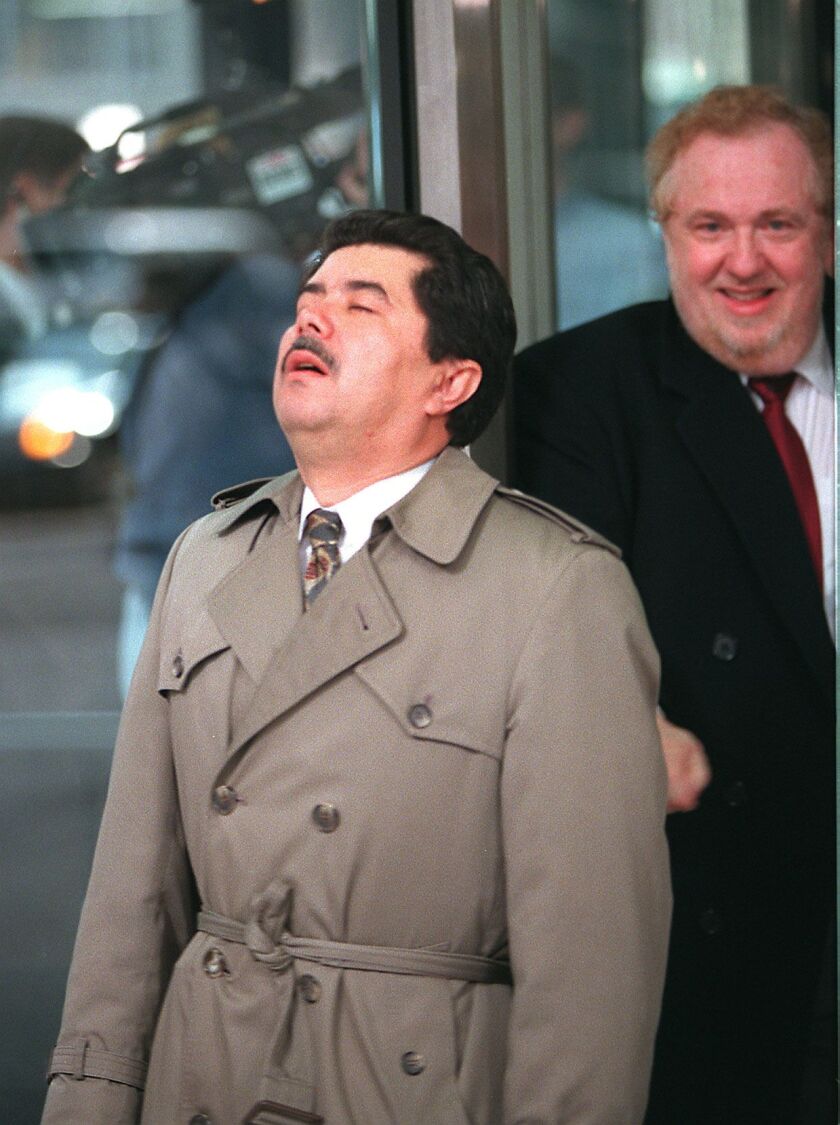 Former Ald. Miguel Santiago breathes a sign of relief after being acquitted of all ghost payrolling charges in 1999, as he exits the federal building with his attorneys, Ed Genson.