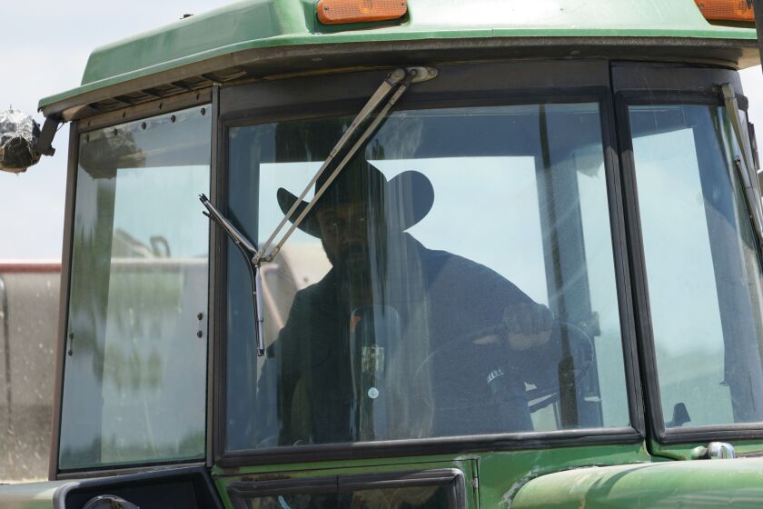 John Boyd Jr. runs his hay bailer at his farm in Boydton, Va.
