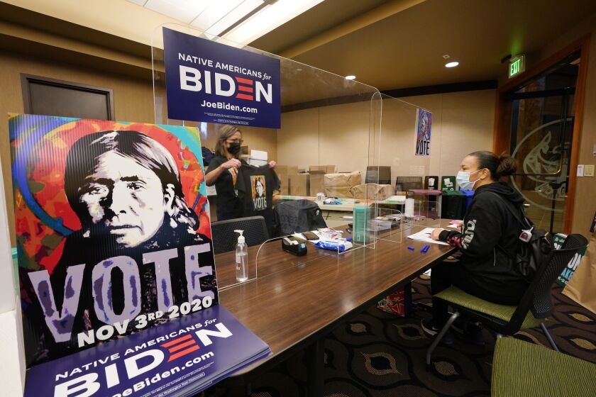 Lummi Tribal member Patsy Wilson (right) is assisted by Lummi Native Vote Team 2020 volunteer Kelli Jefferson in voting on the Lummi Reservation near Bellingham, Washington.