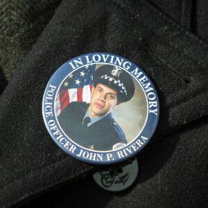 An funeral attendee wears a button for Chicago Police Officer John P. Rivera. | Ashlee Rezin/Sun-Times