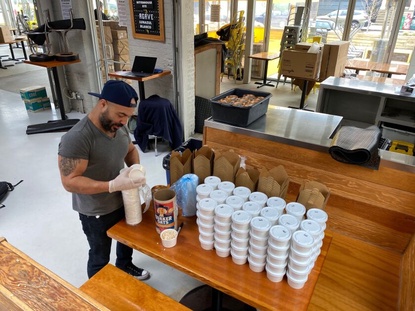 Oat meal is packaged into individual servings at Big Star in Wicker Park. The breakfast staple is among the shelf-stable items packed into grocery bags and distributed for free to Chicago-area unemployed restaurant workers.